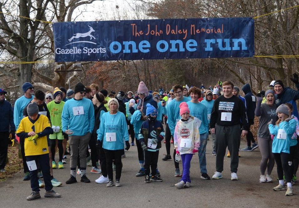 Participants gather at the starting line for the "The John Daley Memorial One One Run" event, organized by Gazelle Sports.